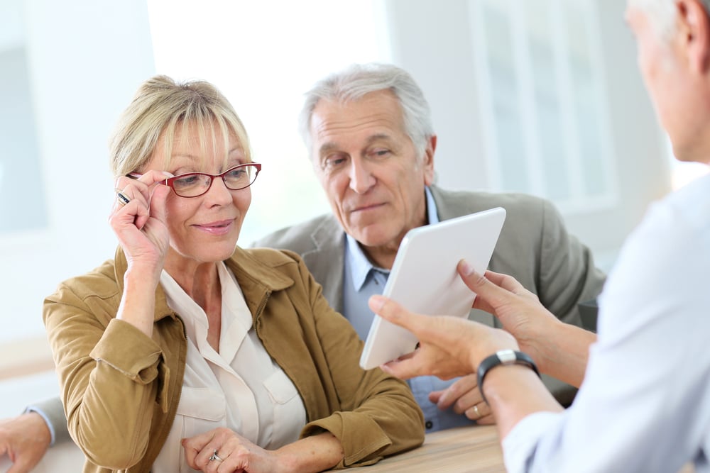 Senior woman at optical store choosing eyeglasses